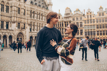 couple standing in front of a crowded city center in europe grand palace