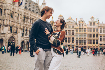 couple standing in front of a crowded city center in europe grand palace