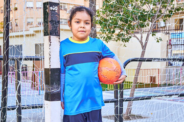 close up of a latin girl football player on a soccer goal with football ball