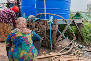 Cambogia, Phnom Penh, donne prendono l’acqua dalle botti del villaggio di Pum Cham