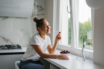 Young woman nutritionist blogger conducts a consultation or an open lesson by video link telling...