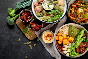 Vegetarian and various vegan dishes on dark table.