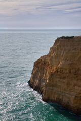 Obraz premium Limestone rock srurrounded by water in the Atlantic Ocean on a winter day in southern Portugal on the Seven Hanging Valleys Trail.