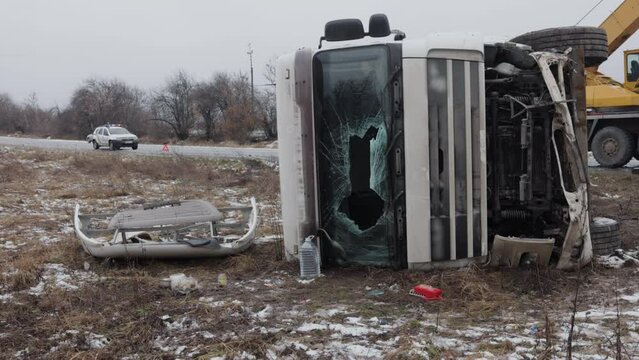 Roadside accident, Windshield replacement, Emergency care. A truck has suffered an accident, with a broken windshield and is now on the roadside, with a police car in the background, lights flashing.