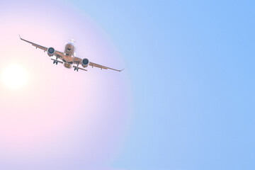 passenger airliner coming in for landing, against the backdrop of a brightly iridescent sky and the...