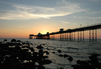 Obraz premium The sun rising over Llandudno pier.