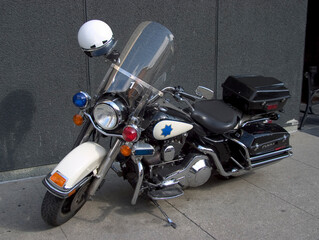 A fancy police motorcycle sits parked on the sidewalk.
