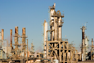 The complex arrangement of metal pipes and smoke stacks of a modern oil refinery.