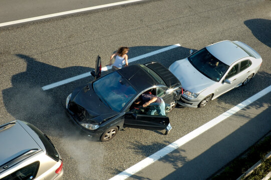 A small shunt on the freeway (motorway, autoroute, autobahn) a few seconds after it happened. Steam can be seen coming from under the bonnet of the black car. Motion blur on the passenger fleeing in p