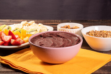 Brazilian açaí in a bowl accompanied by tropical fruits. Fruit of the Amazon