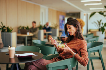 Caucasian businesswoman eat breakfast at work.