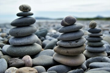 Fototapeta na wymiar Towers made of pebbles. Three Zen towers on a rocky beach.