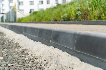 Construction of a pedestrian path. Paving of pedestrian paths on city streets. Road curbs and...