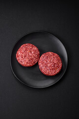 Fresh raw ground beef burger patty with salt and spices