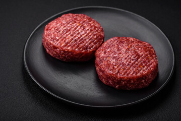 Fresh raw ground beef burger patty with salt and spices
