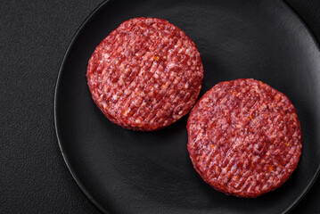 Fresh raw ground beef burger patty with salt and spices