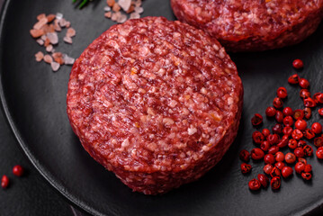 Fresh raw ground beef burger patty with salt and spices