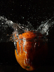 This is a photo of an orange falling into the water, captured at 1/45000 of a second, so that the splash of water drops is sharp.