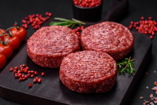 Fresh raw ground beef burger patty with salt and spices