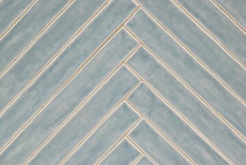 Long blue gray tile pattern with light glaze finish, diagonal pattern on a wall, background image. Color swatch design sample. 