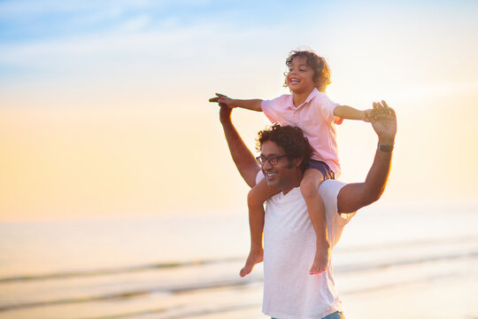 Father and child playing on tropical beach