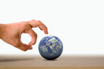 Male hand flicking the earth on a wooden surface