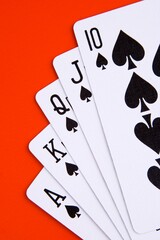 Royal flush in spades with red background.