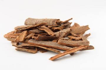 Cinnamon sticks chopped, isolated on white. Shallow depth of field, focused on the centre of the pile.