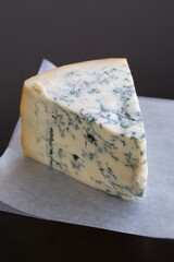 Aged Mountain blue cheese wedge on wax paper on a table