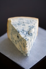 Soft Focus Aged Mountain blue cheese wedge on wax paper on a table