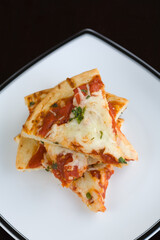 Slices of plain pizza stacked on a plate