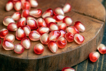 Red pomegranate seeds on the table and the board