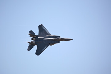 Fototapeta na wymiar F-15 strike eagle in flight against blue sky, banking hard right