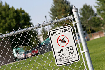 drug and gun free school zone sign at a school yard. sign of the times.