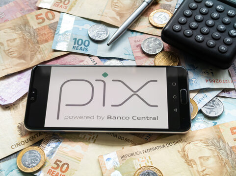 Bahia, Brazil, 02 june 2023. Pix application on the smartphone screen on coins and banknotes of Brazilian money