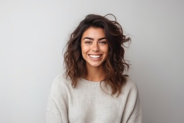 Obraz premium Portrait of a happy young woman looking at camera over grey background