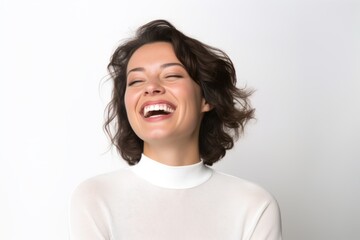 Portrait of a beautiful young woman laughing on a white background.