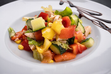 fresh vegetable and chicken fillet salad on a white plate