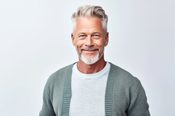 Obraz premium Handsome mature man looking at camera and smiling while standing against white background