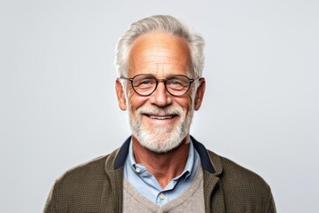 Portrait of happy senior man in eyeglasses against grey background