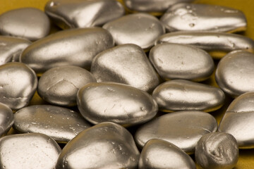 Silver pebbles against a gold background