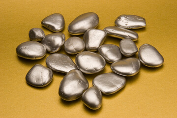 Silver pebbles against a gold background