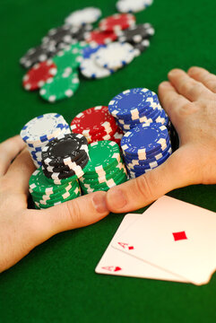 Poker player going "all in" pushing his chips forward