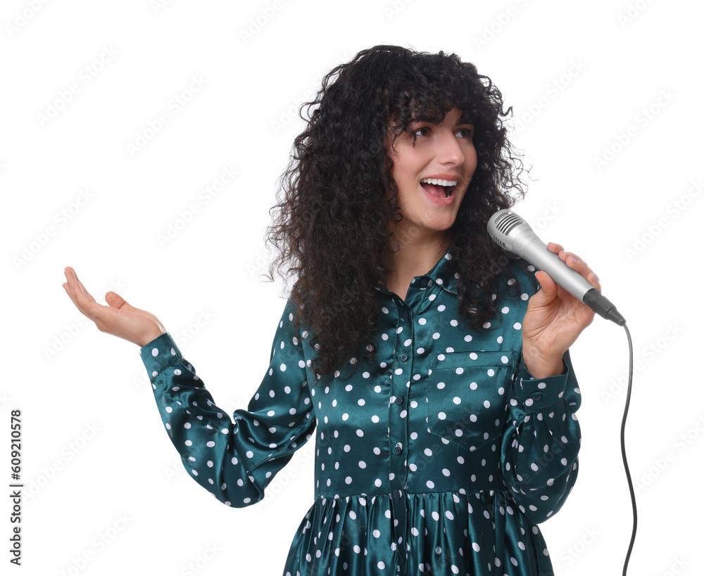 Wall mural Beautiful young woman with microphone singing on white background