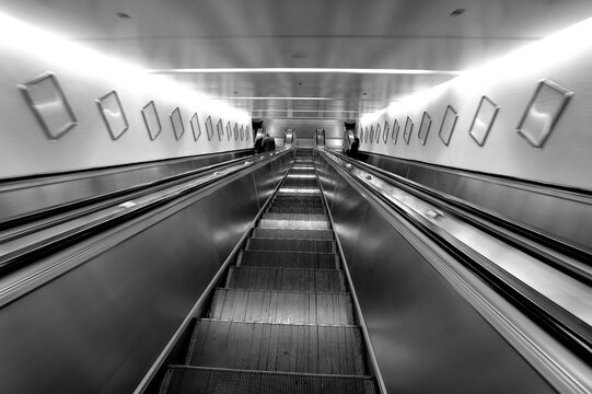 three escalators, going down view, black and white photo