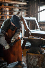 Blacksmith manually forging metal object in a rustic workshop 