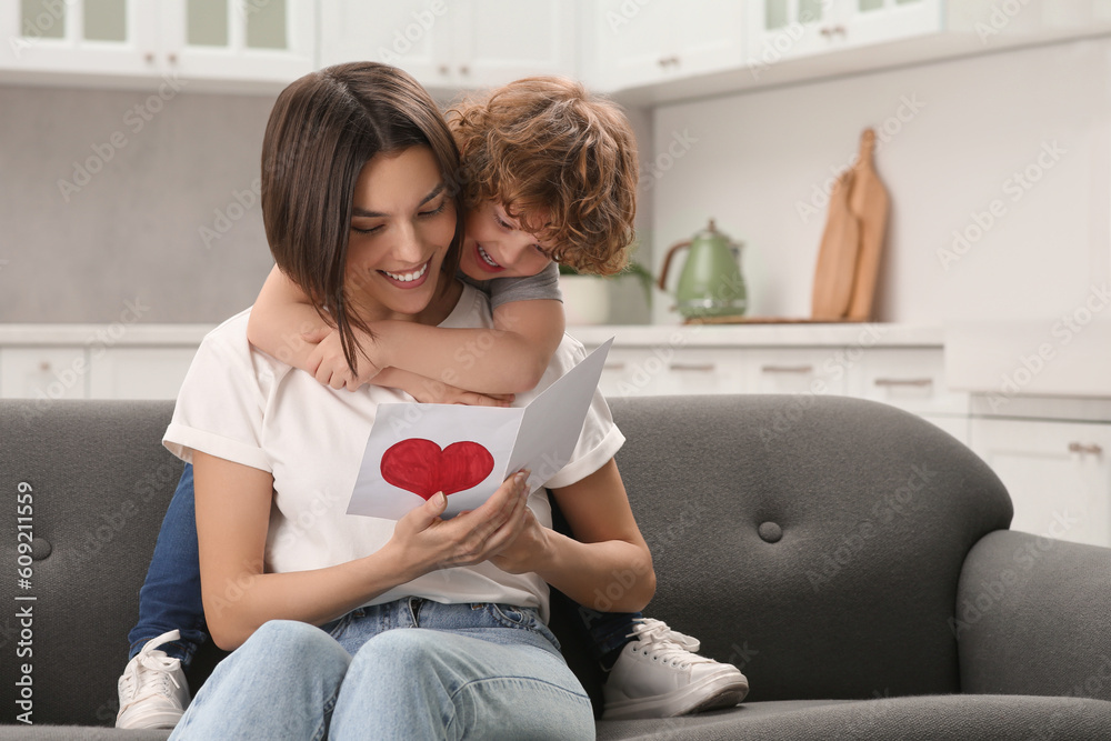 Canvas Prints Little son congratulating his mom with Mother`s day at home. Woman holding greeting card