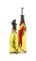 Glass bottles of cooking oils with spices and herbs on white background