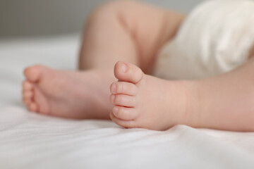 Obraz na płótnie Canvas Cute little baby in diaper on bed, closeup