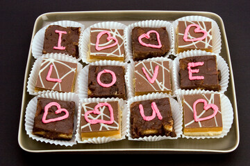 Chocolate cakes with 'I love you' and 'love hearts' written in icing.
